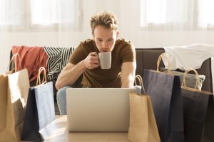 man drinking coffee while working on a laptop